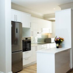 Ballito interior design kitchen with contemporary cabinetry, appliances and hardwood flooring.