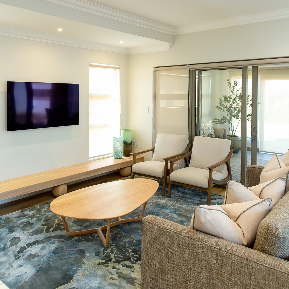 Ballito interior design living room with custom sofa, oak armchairs, TV unit, ash wood coffee table and imported rug.